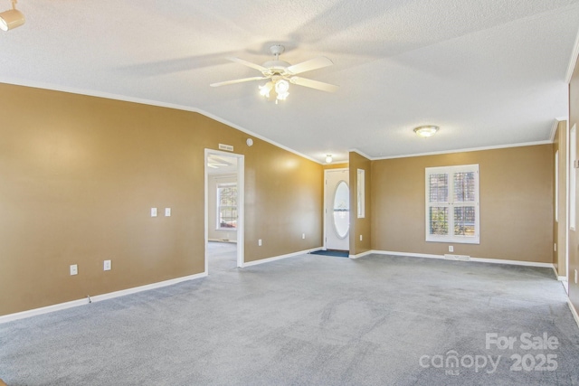 spare room featuring crown molding, lofted ceiling, light carpet, and a textured ceiling