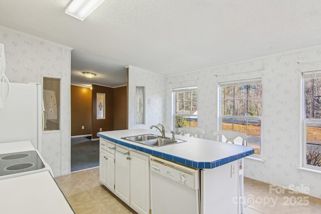 kitchen featuring light tile patterned flooring, white cabinetry, sink, a center island with sink, and white appliances