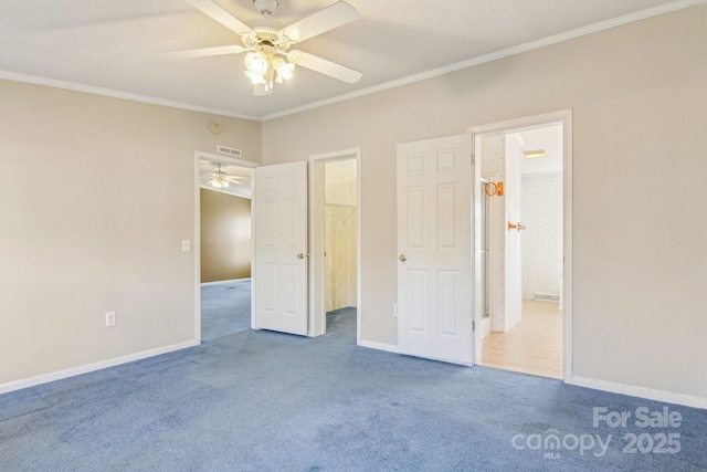 unfurnished bedroom featuring ornamental molding, a spacious closet, light colored carpet, and ceiling fan