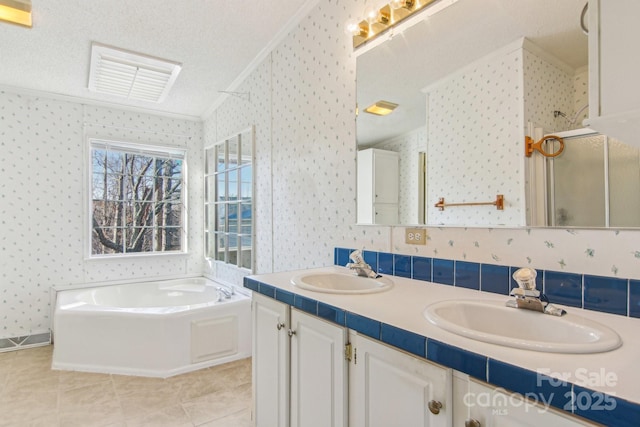 bathroom with tile patterned flooring, vanity, ornamental molding, a textured ceiling, and separate shower and tub