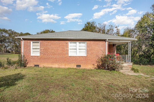 view of property exterior featuring covered porch and a yard