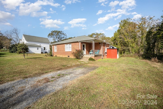 view of front of property with a front yard and a storage shed