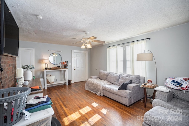 living room featuring ceiling fan, dark hardwood / wood-style flooring, and a textured ceiling