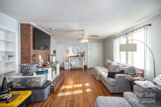 living room with ceiling fan, dark hardwood / wood-style flooring, and a textured ceiling