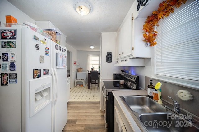 kitchen with stainless steel range with electric stovetop, sink, white refrigerator with ice dispenser, white cabinets, and light hardwood / wood-style floors