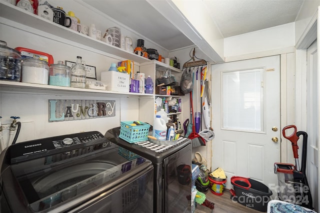 clothes washing area with separate washer and dryer, a textured ceiling, and hardwood / wood-style flooring