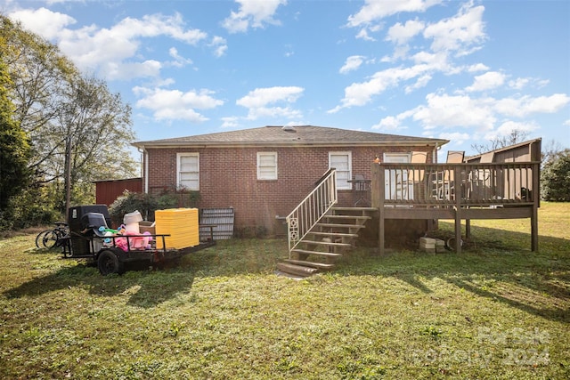 rear view of property featuring a deck and a lawn