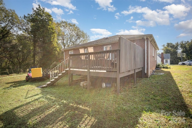 rear view of property featuring a yard and a wooden deck