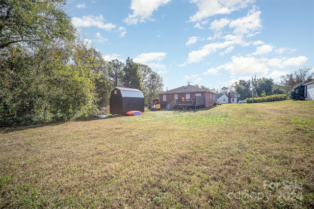 view of yard with a wooden deck and a storage shed