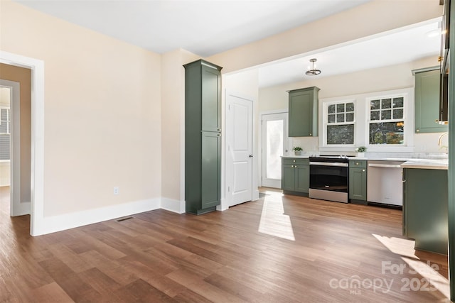 kitchen featuring appliances with stainless steel finishes, light hardwood / wood-style floors, and green cabinetry