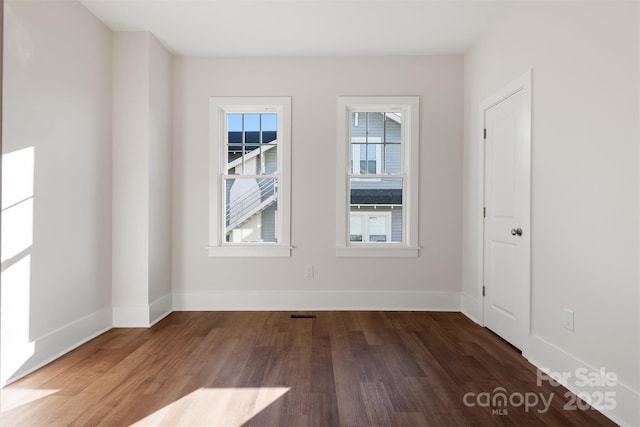 unfurnished room with dark hardwood / wood-style flooring