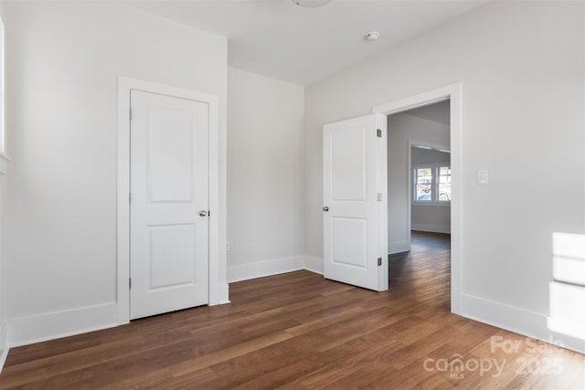 unfurnished room with wood finished floors and baseboards