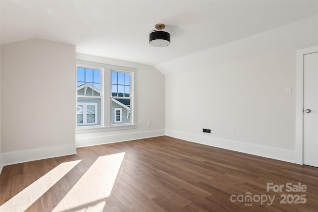 additional living space featuring lofted ceiling, baseboards, and wood finished floors