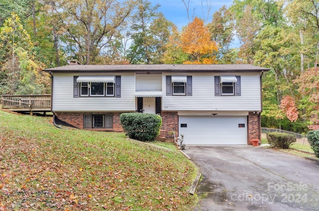 split foyer home featuring a garage and a front lawn