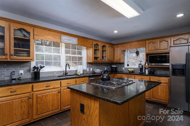 kitchen with plenty of natural light, a center island, sink, and stainless steel appliances