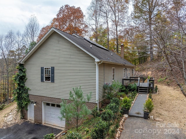 view of side of property with a garage and a deck