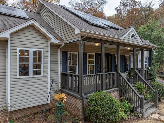 view of front of home featuring solar panels and covered porch