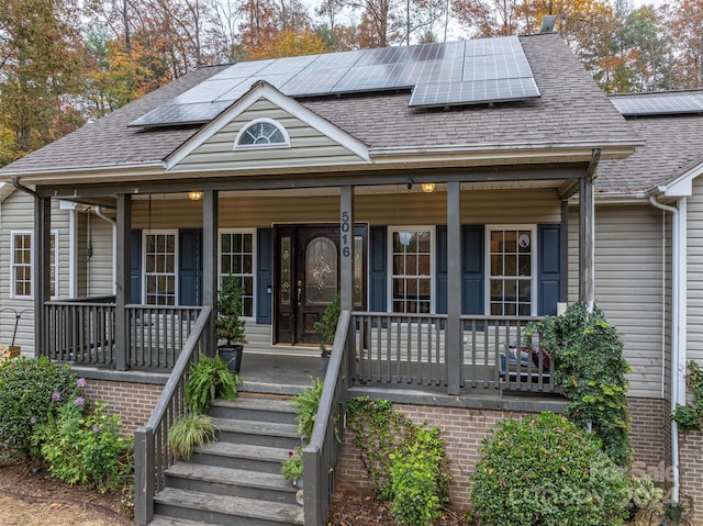 view of front facade featuring solar panels and a porch