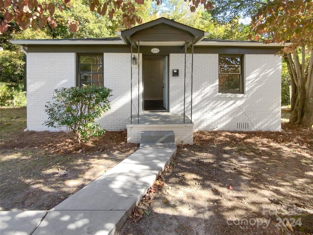 view of front facade with brick siding and crawl space