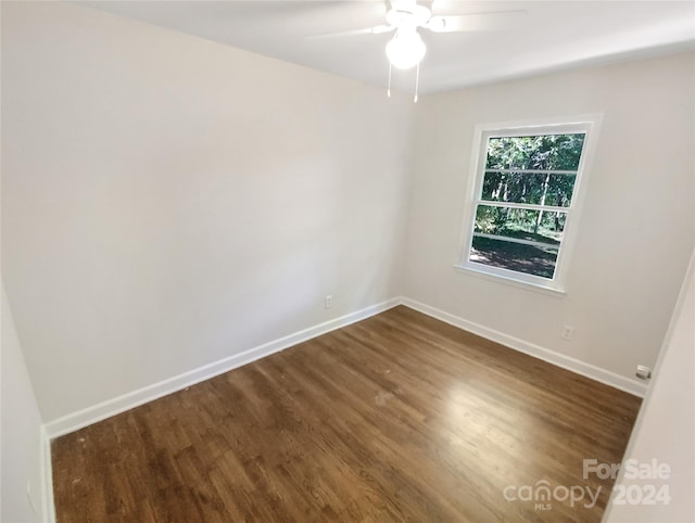 unfurnished room with ceiling fan and dark hardwood / wood-style flooring