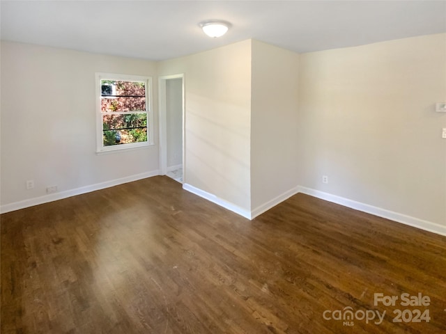 spare room with dark wood-type flooring