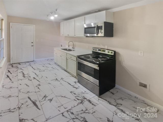 kitchen featuring white cabinetry, stainless steel appliances, sink, and rail lighting