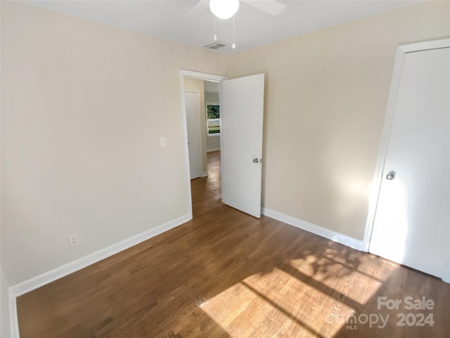 unfurnished bedroom featuring visible vents, baseboards, ceiling fan, and wood finished floors