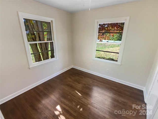 empty room with dark hardwood / wood-style flooring