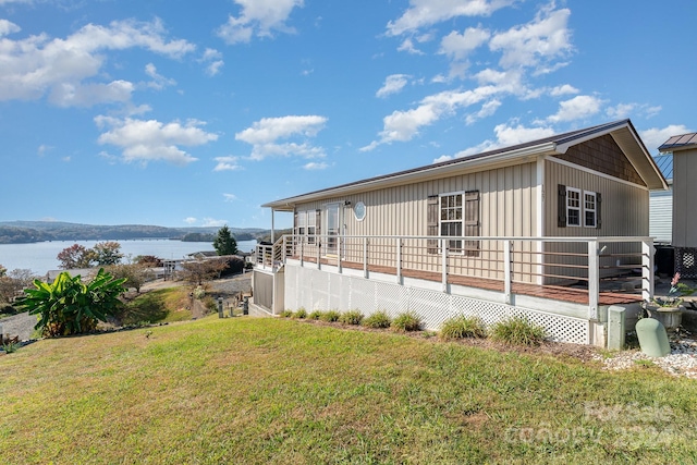 exterior space with a lawn and a deck with water view