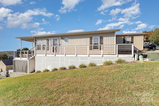 rear view of property with a deck and a lawn