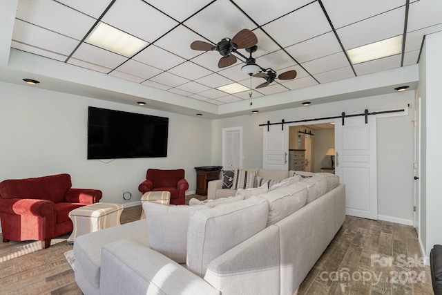 127 Lake View Dr, New London, NC 28127 - living area with wood finished floors, a barn door, a ceiling fan, a tray ceiling, and baseboards