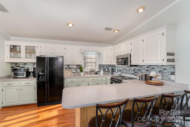 127 Lake View Dr, New London, NC 28127 - kitchen with black fridge, stainless steel microwave, a sink, electric range, and a peninsula