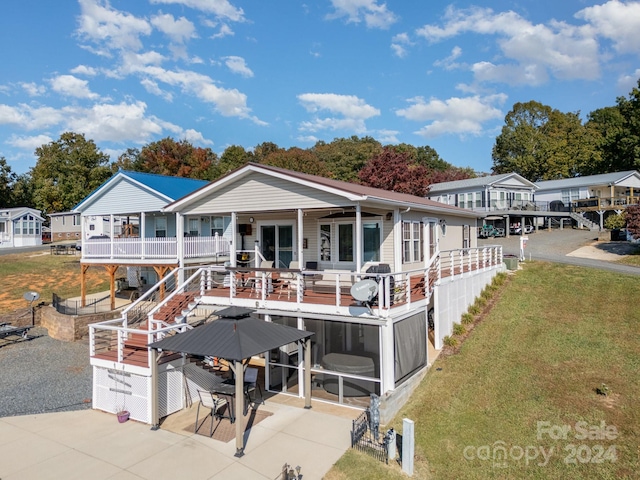 rear view of property featuring a patio and a lawn