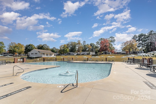 view of swimming pool featuring a yard and a patio area