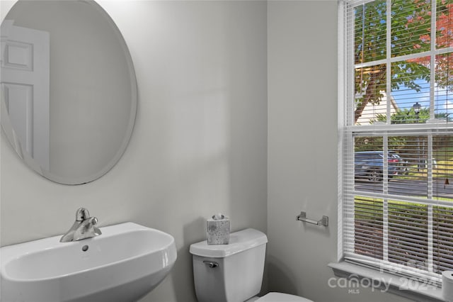 bathroom with a wealth of natural light, sink, and toilet