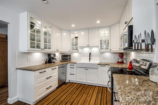 kitchen featuring white cabinets, decorative backsplash, stainless steel appliances, and sink