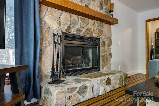 room details with a stone fireplace and hardwood / wood-style floors