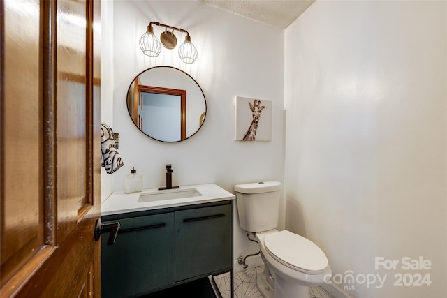 bathroom with vanity, a textured ceiling, and toilet