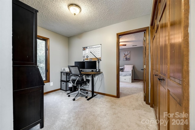 carpeted office space featuring a textured ceiling