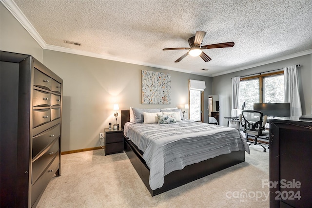 bedroom with ceiling fan, light colored carpet, and a textured ceiling