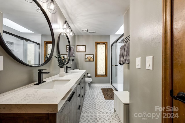 bathroom featuring vanity, toilet, and a shower with shower door