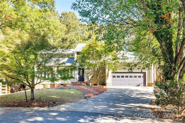 view of property hidden behind natural elements featuring a garage