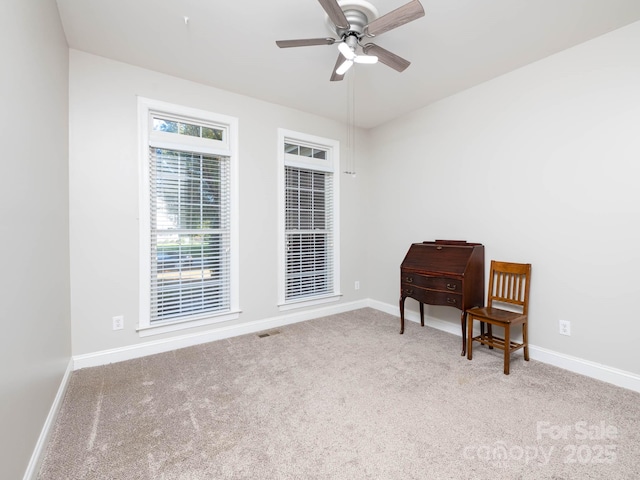 living area featuring light carpet and ceiling fan