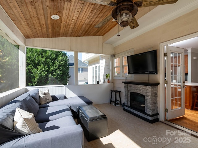 tiled living room featuring ceiling fan, an outdoor stone fireplace, vaulted ceiling, and wooden ceiling