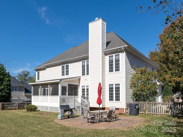 back of property with a patio, a sunroom, and a lawn