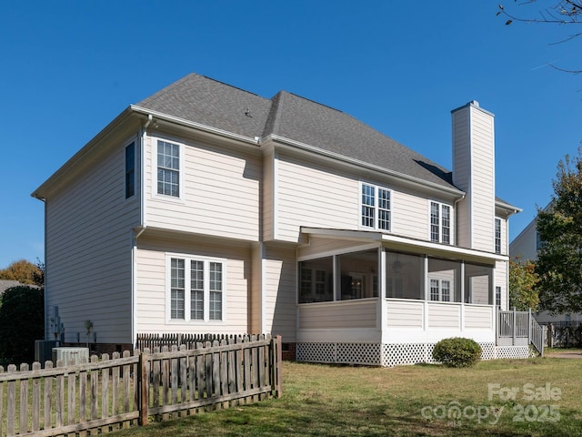 rear view of house with a yard and a sunroom