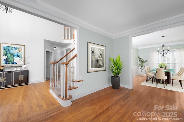 corridor featuring crown molding, wood-type flooring, and a chandelier