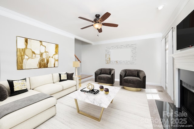 living room with ceiling fan and ornamental molding