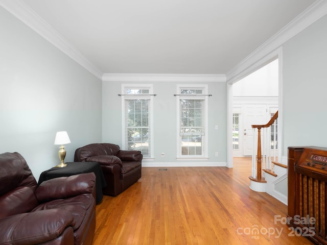 living room with ornamental molding and light hardwood / wood-style flooring