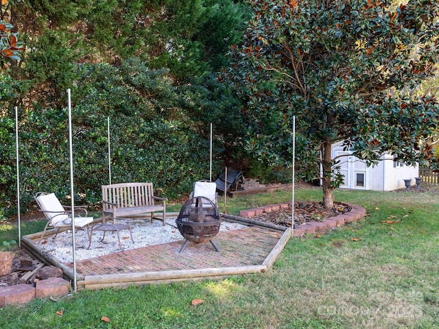 view of yard featuring a storage shed and an outdoor fire pit